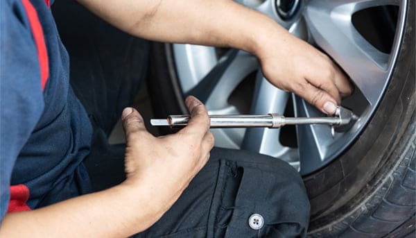 mechanic checking tire pressure
